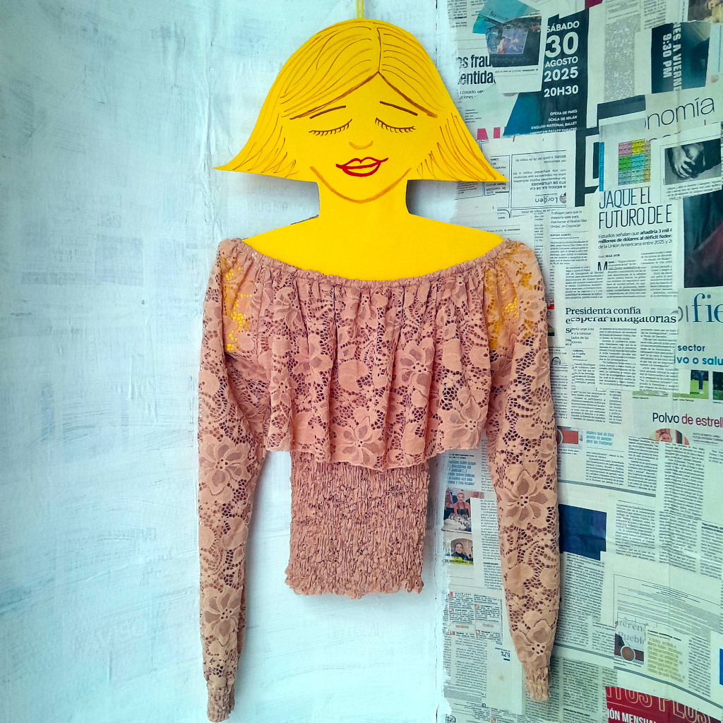 Blusa rosa de encaje colgada en un maniquí
