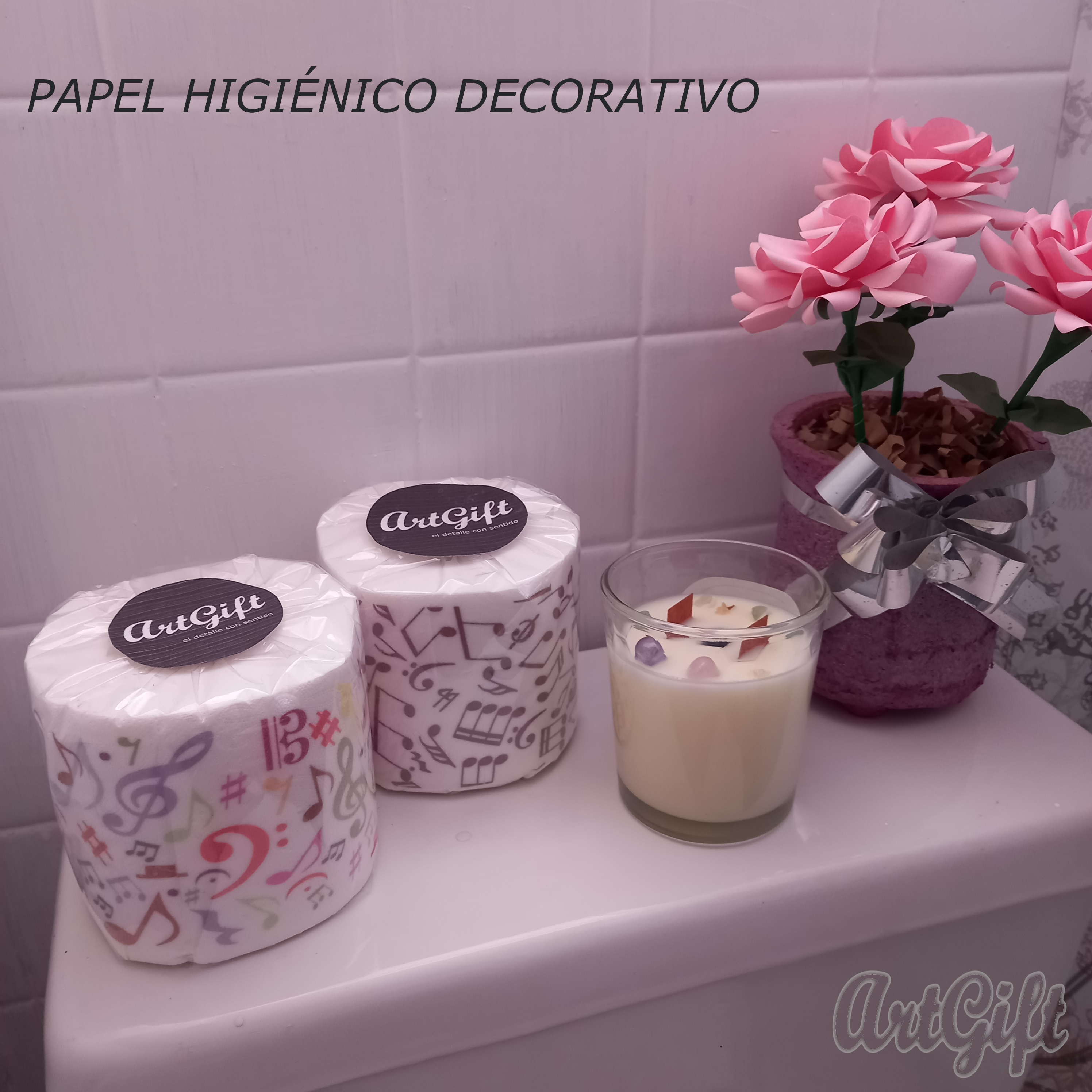 Caja de WC sobra la que hay rollos de papel higiénico decorado con notas musicales.